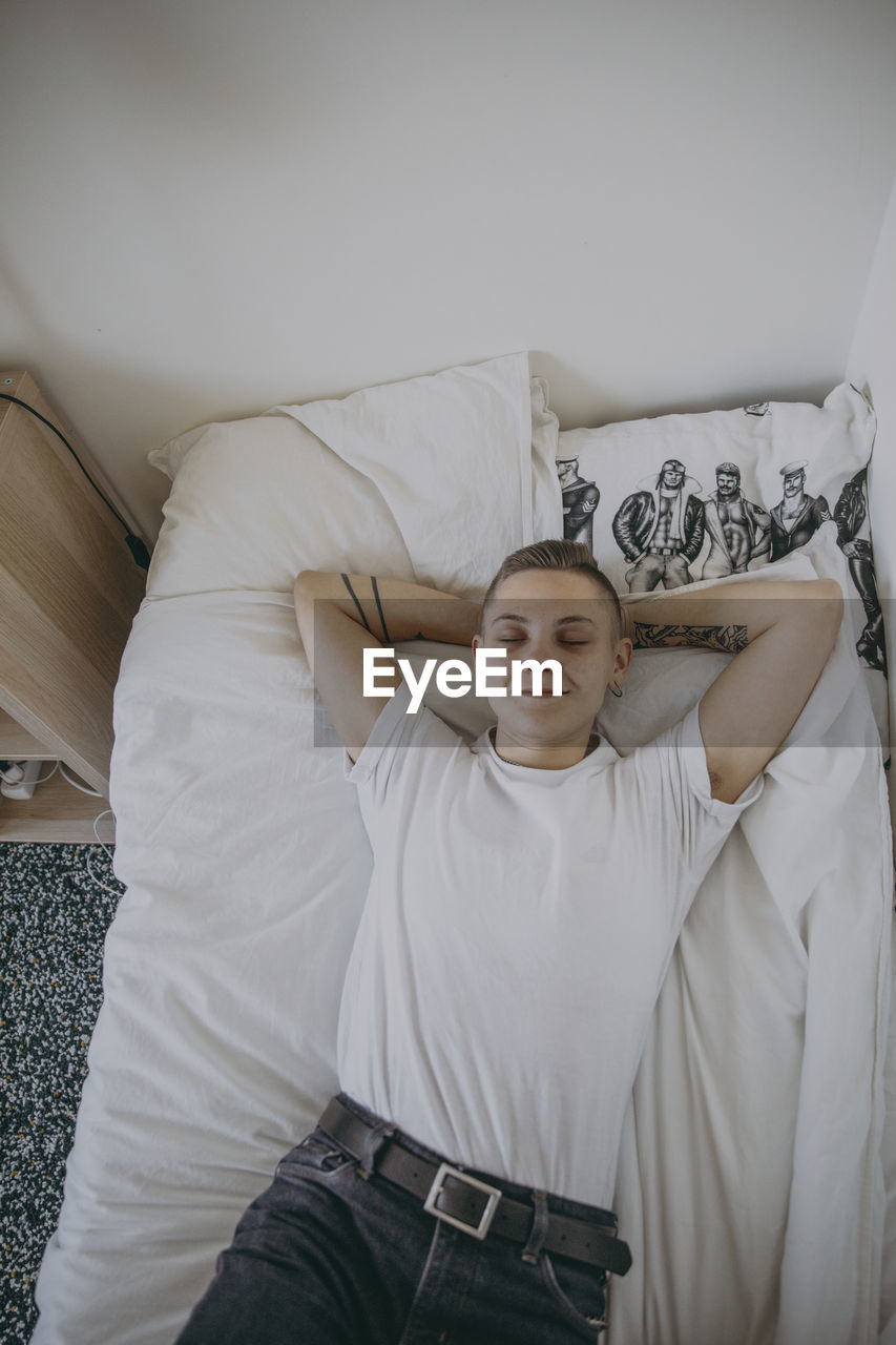 Woman lying on bed with eyes closed