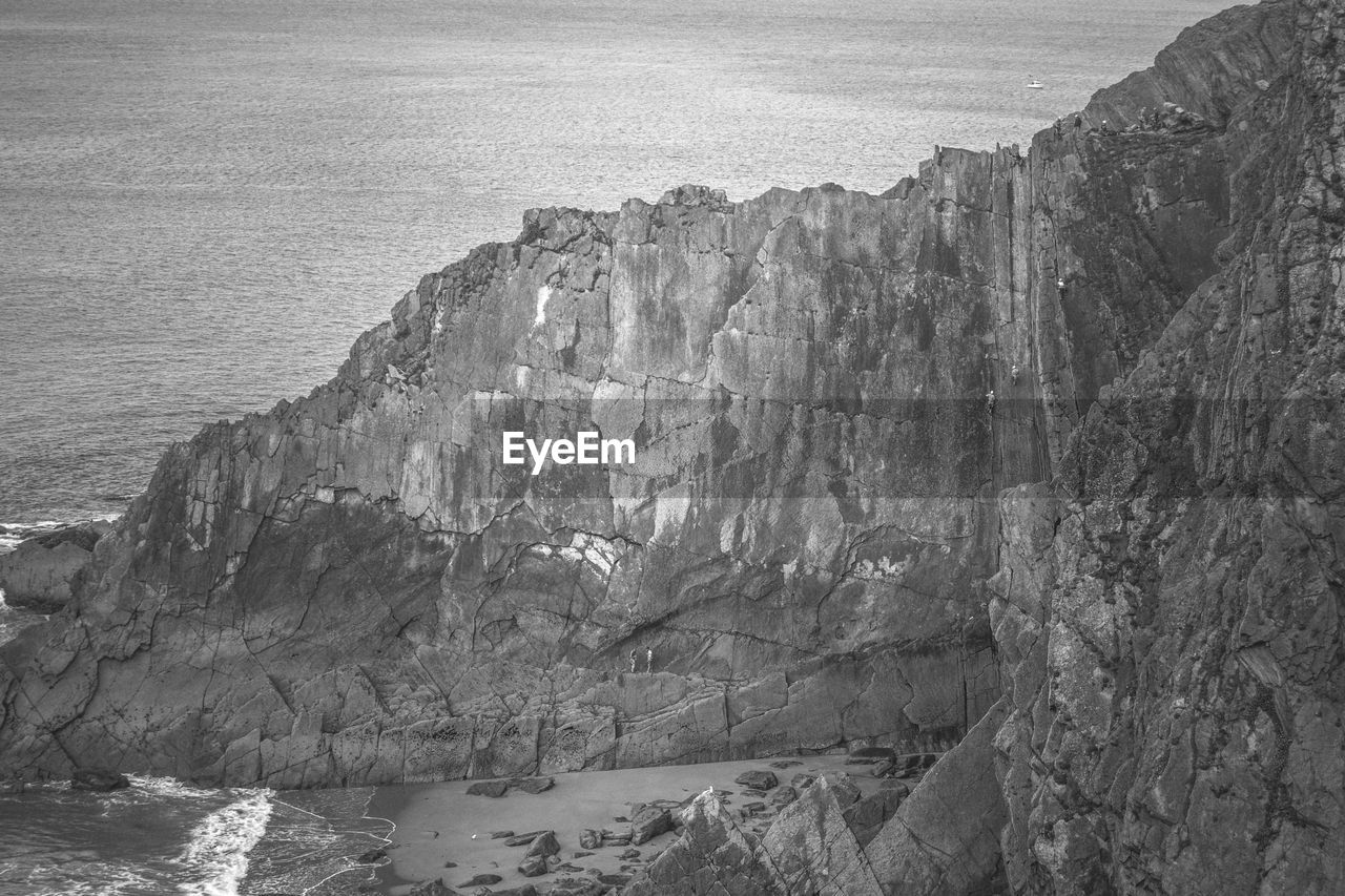 HIGH ANGLE VIEW OF ROCK FORMATIONS ON SEA