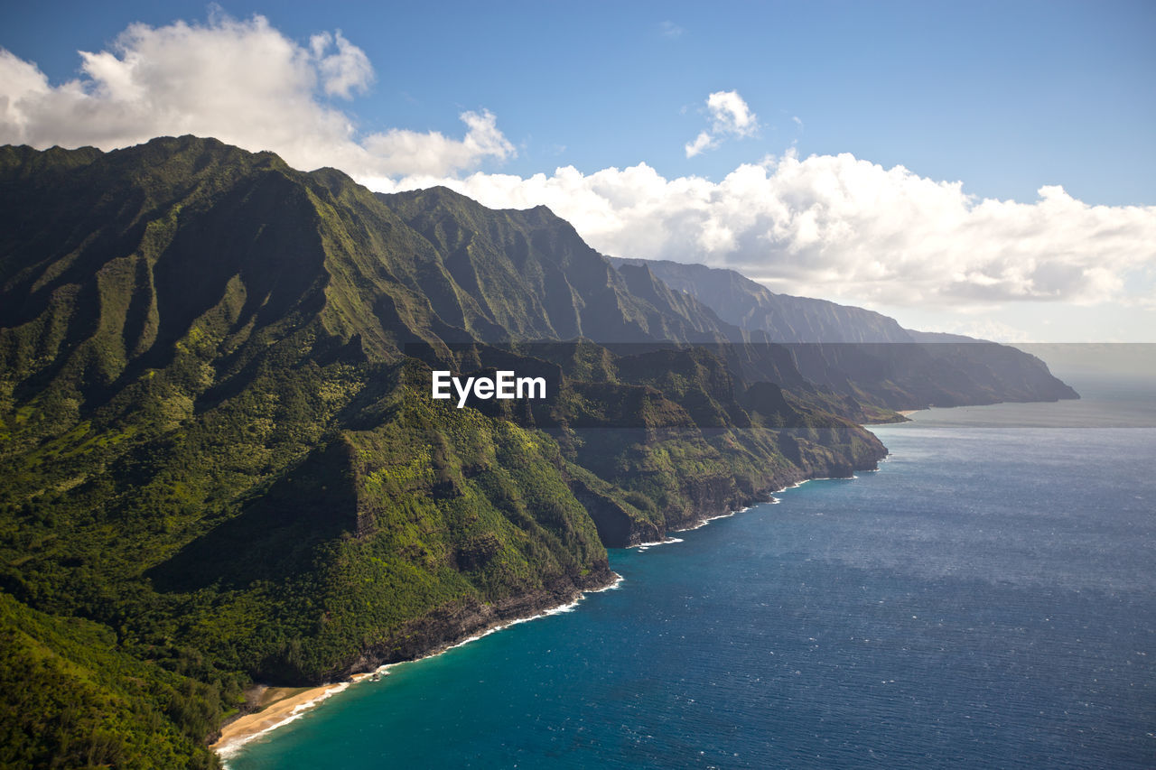 Scenic view of sea and mountains against sky