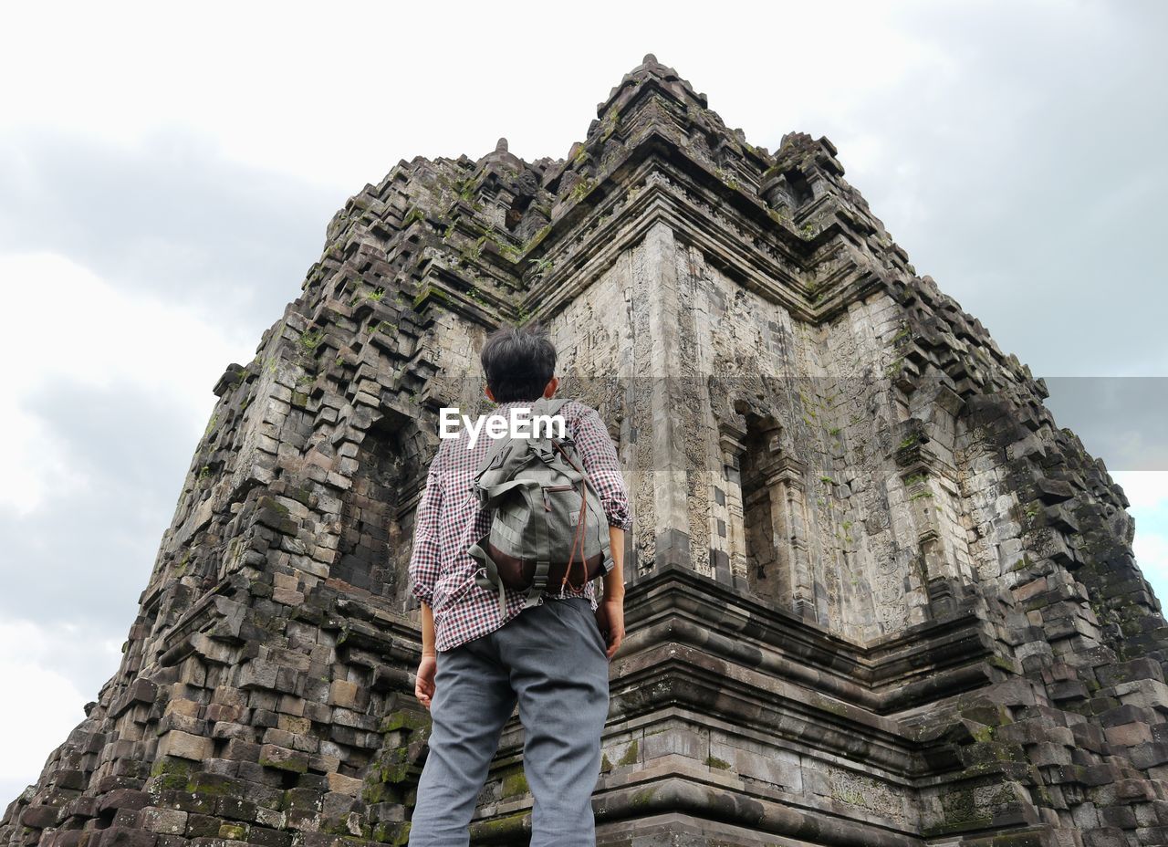 Low angle view of man looking at temple