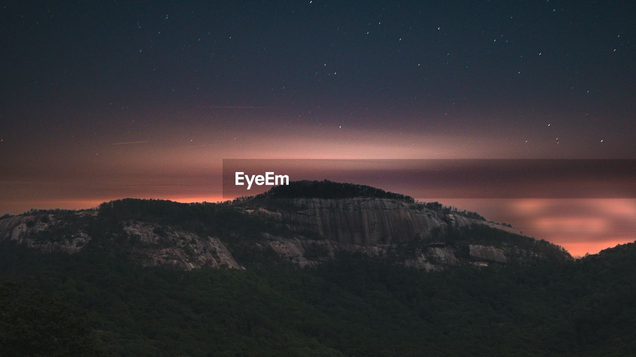 Scenic view of mountains against sky at dusk