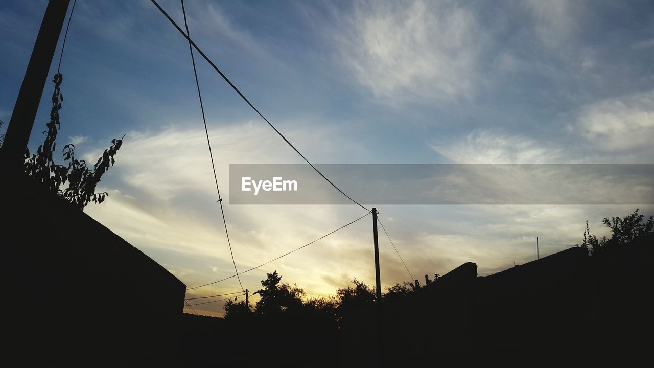 Low angle view of silhouette trees against sky