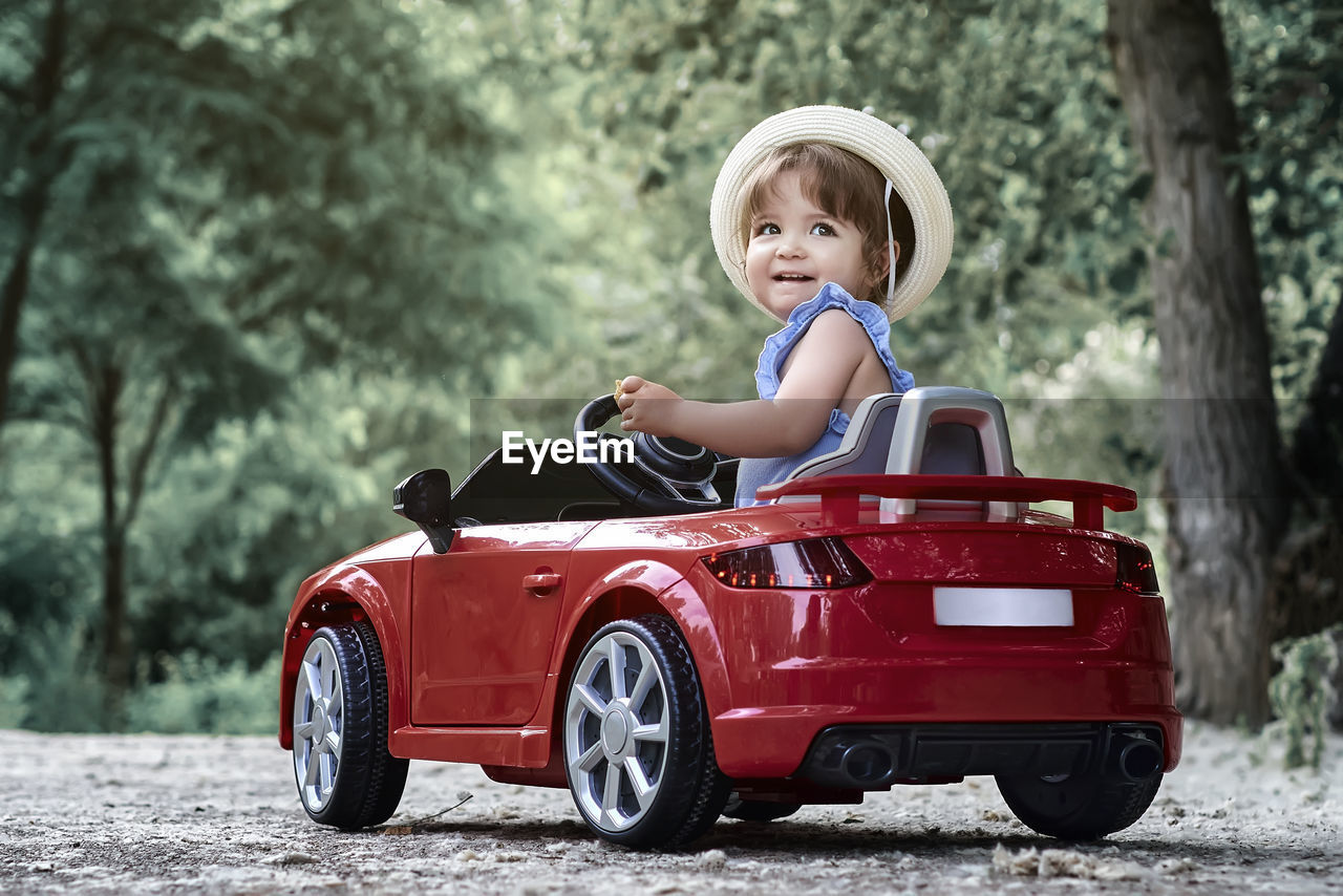 A girl riding a toy car