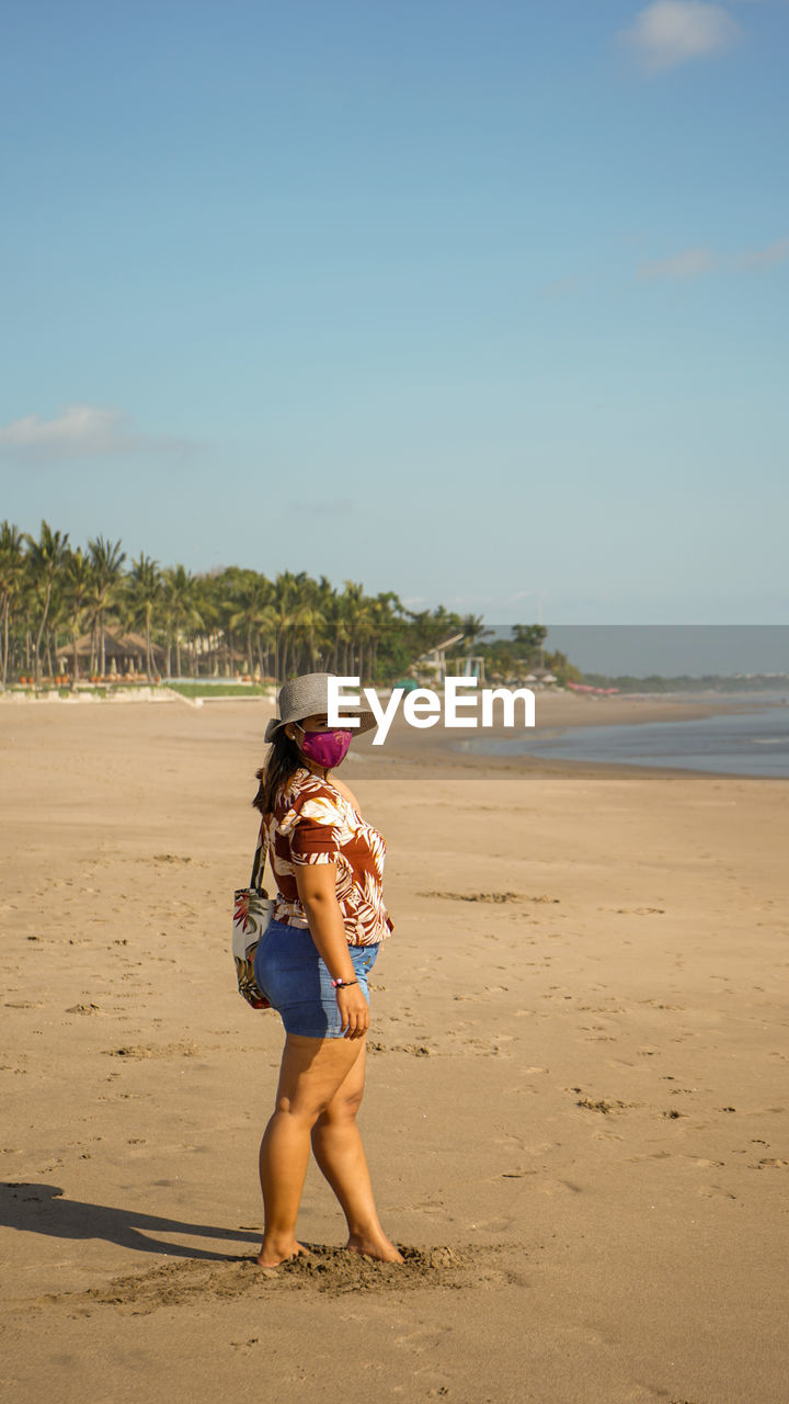 Full length of woman on beach against sky