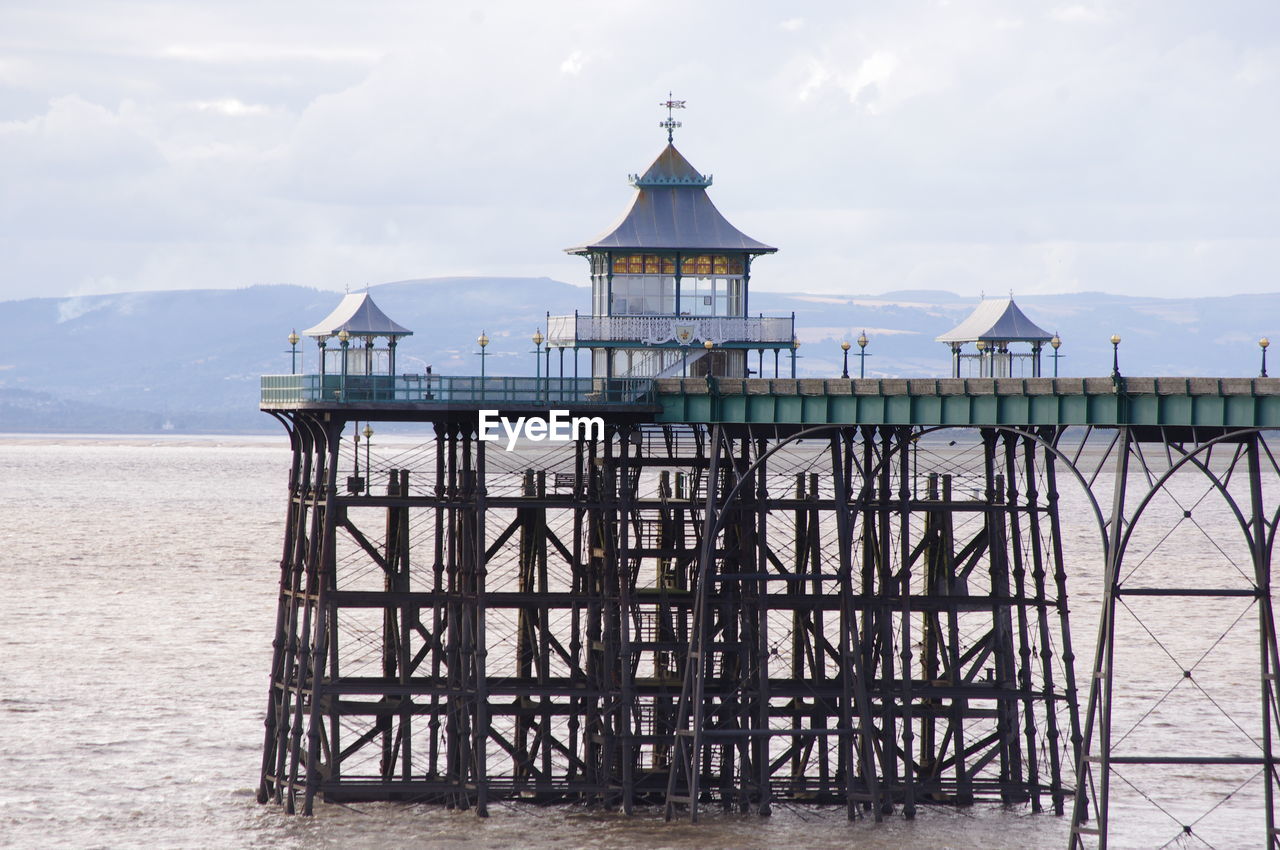 STILT HOUSE ON BEACH AGAINST SKY