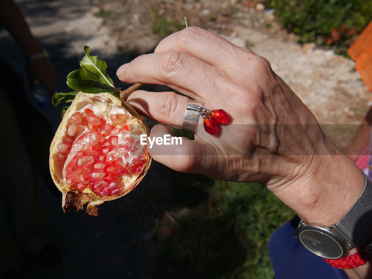 CLOSE-UP OF HAND HOLDING STRAWBERRY WITH STRAWBERRIES