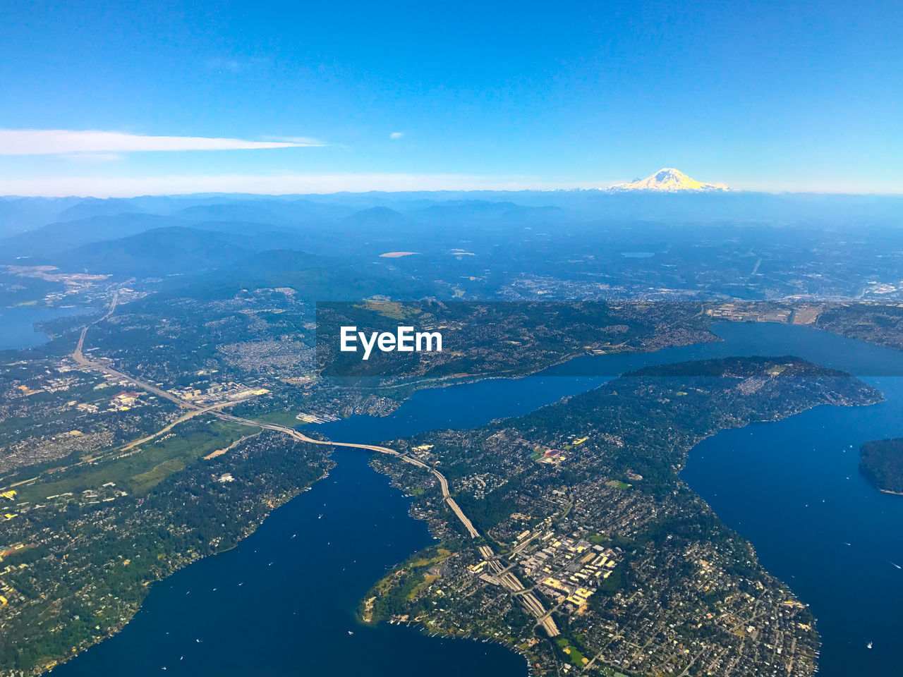 Aerial view of city by sea against sky