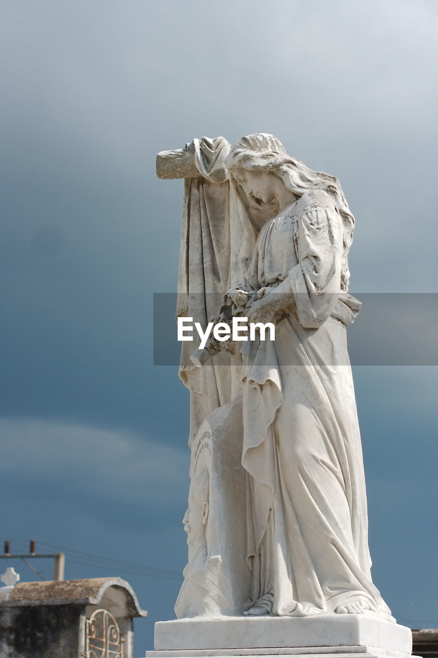 Sad woman cemetery statue in camaguey, cuba.