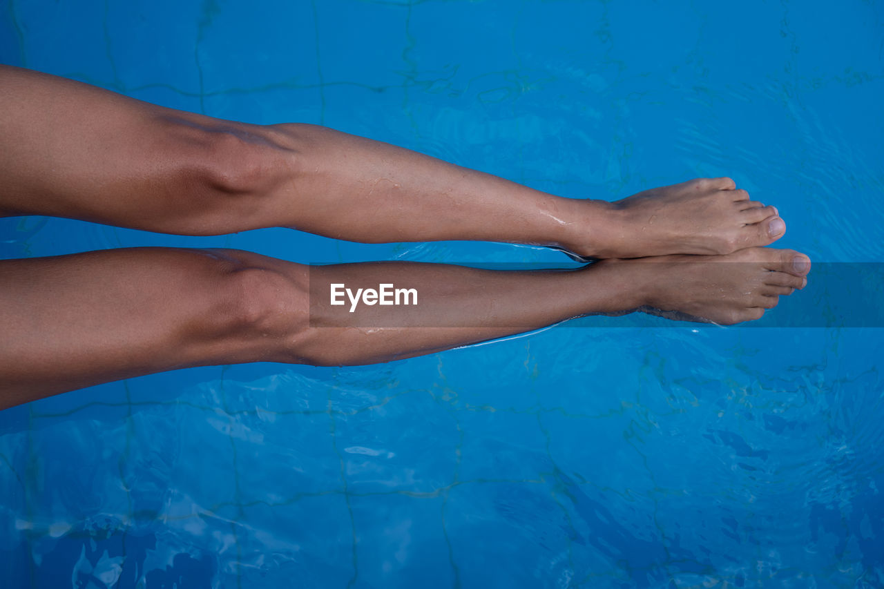 LOW SECTION OF WOMAN ON SWIMMING POOL
