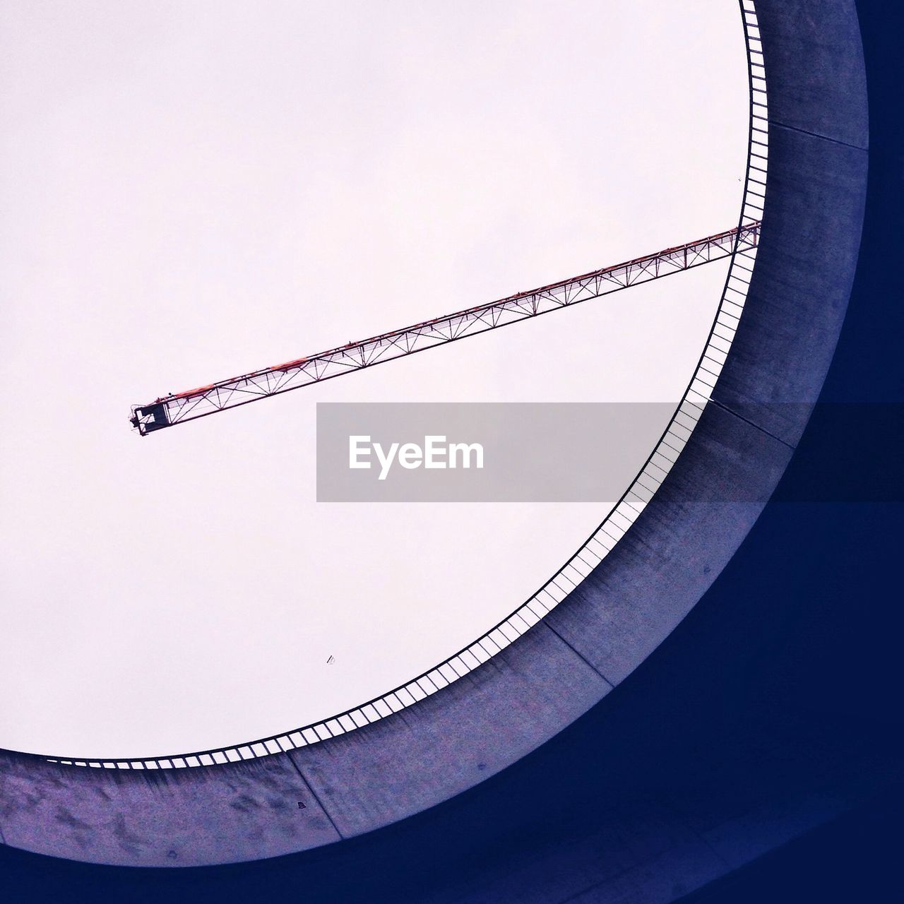 Built structure and crane against sky