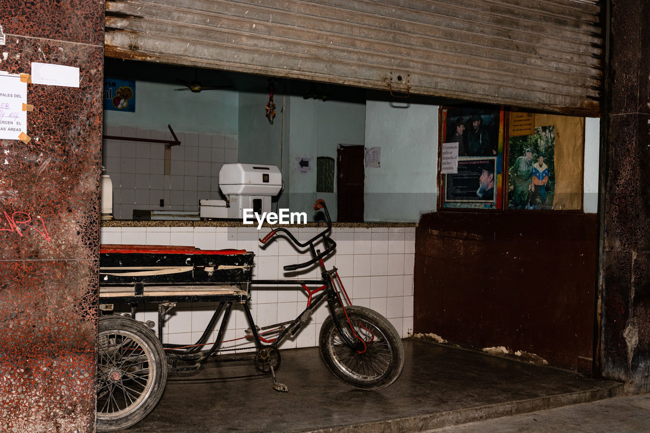 BICYCLE PARKED BY WALL IN CITY