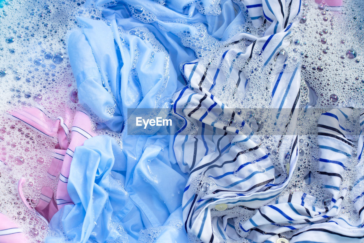 Full frame shot of wet textile with soap sud