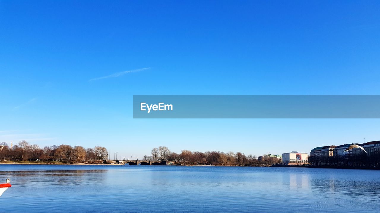 Scenic view of lake against clear blue sky