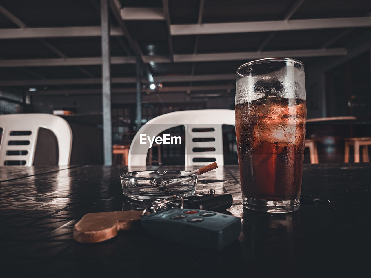 Close-up of drink on table with a cigarette and car keys