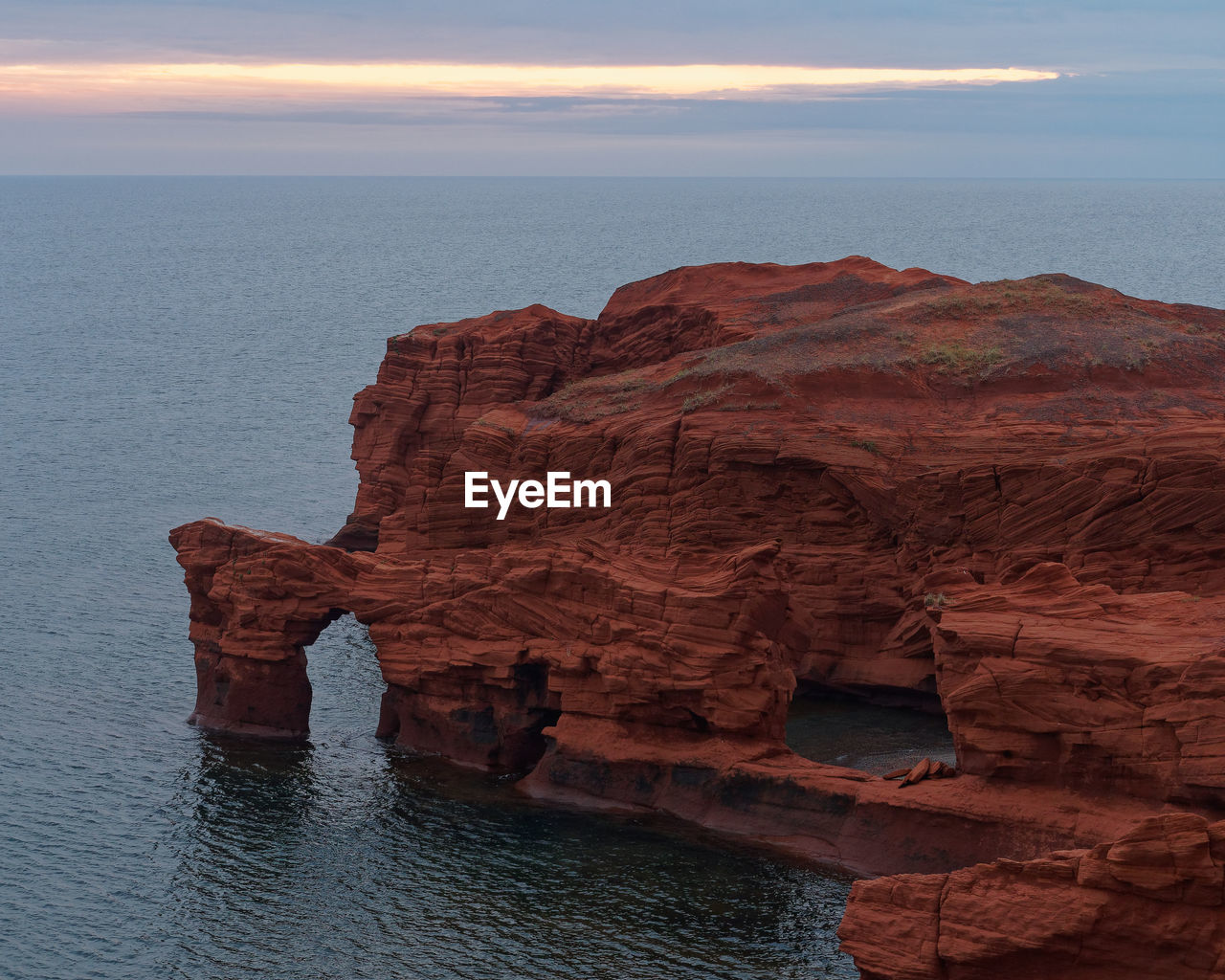 ROCK FORMATION IN SEA AGAINST SKY