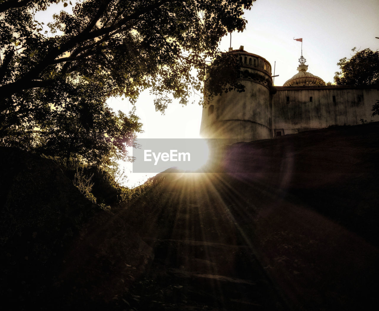 LOW ANGLE VIEW OF BUILDING AGAINST SUNSET