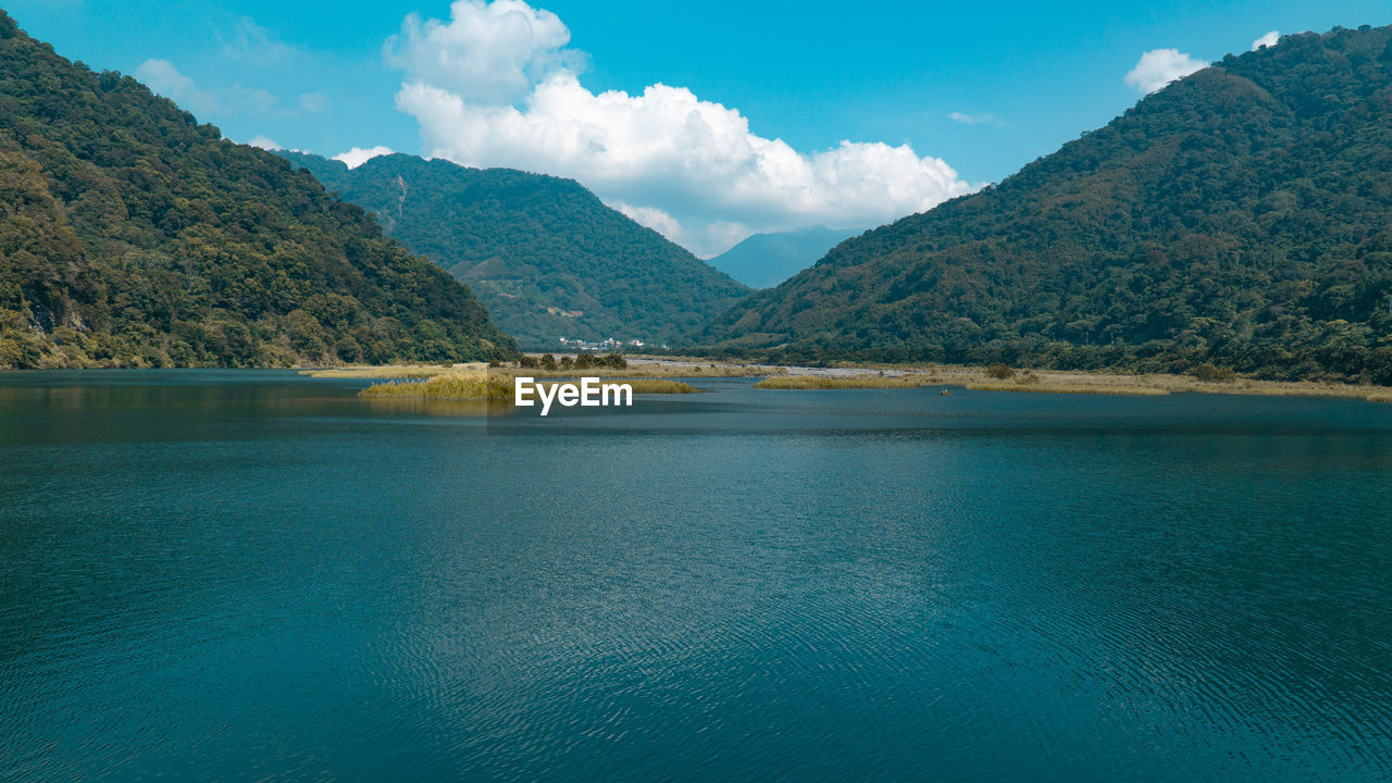 Scenic view of lake and mountains against sky