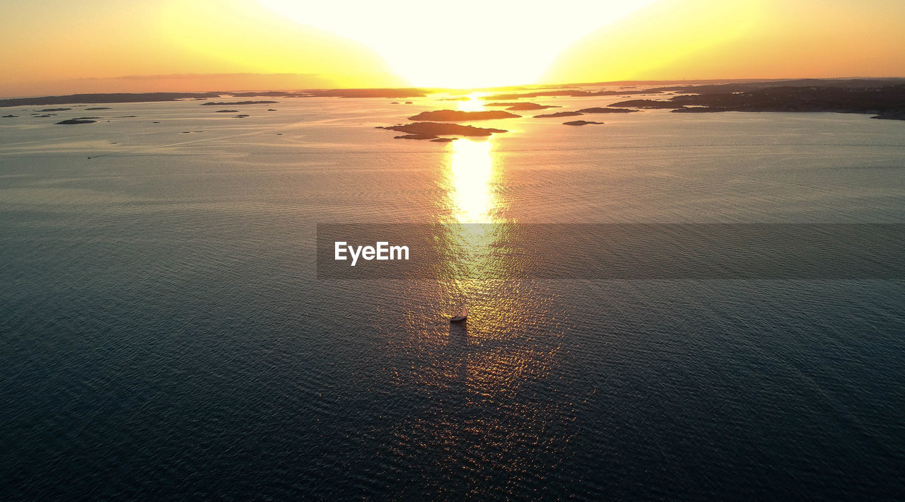 SCENIC VIEW OF SEA AGAINST ORANGE SKY