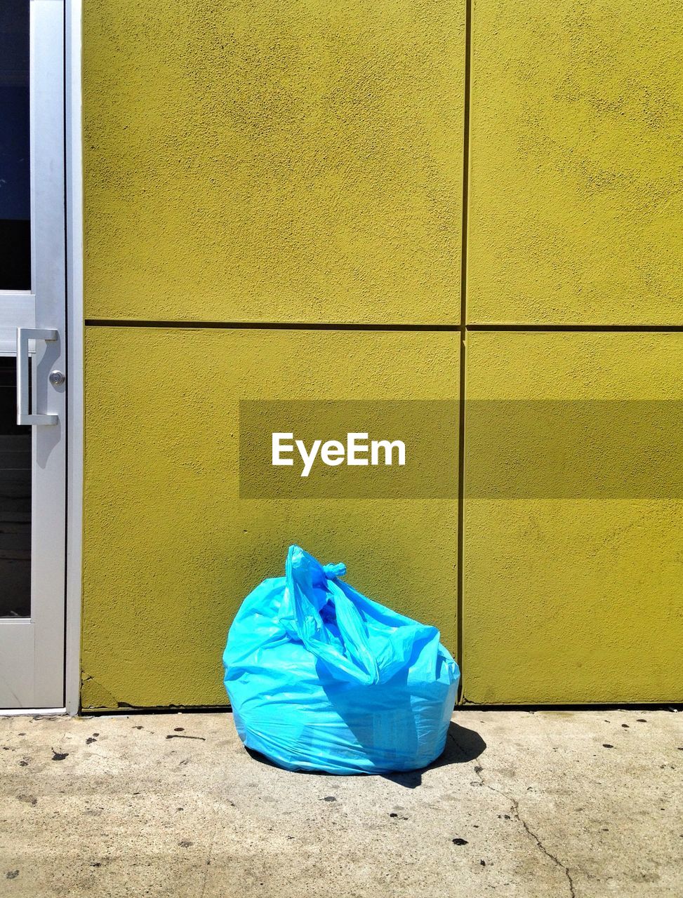 Blue plastic bag against building