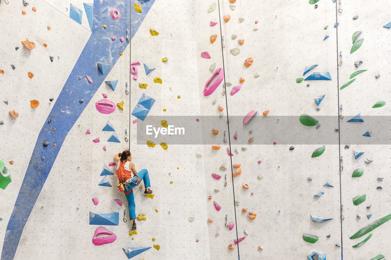 Low angle view of woman climbing on wall