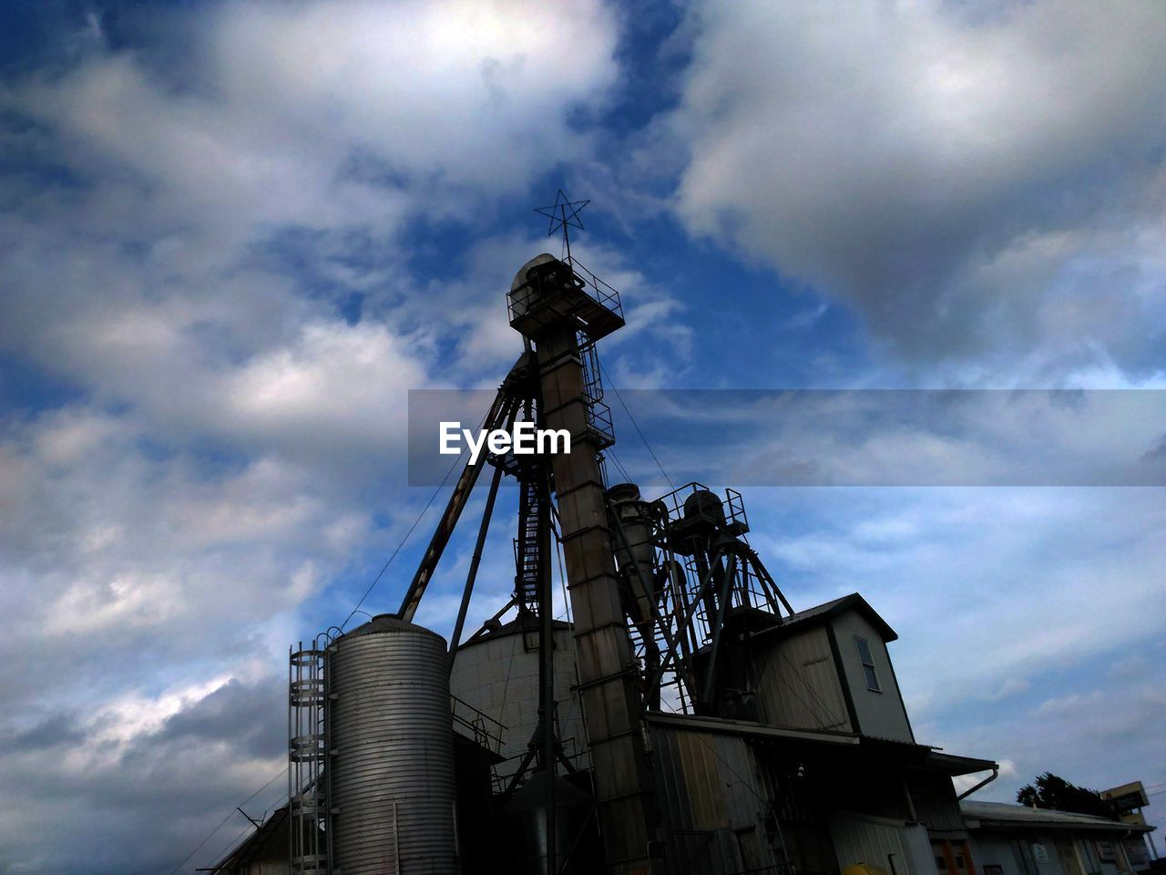 LOW ANGLE VIEW OF FACTORY AGAINST CLOUDY SKY