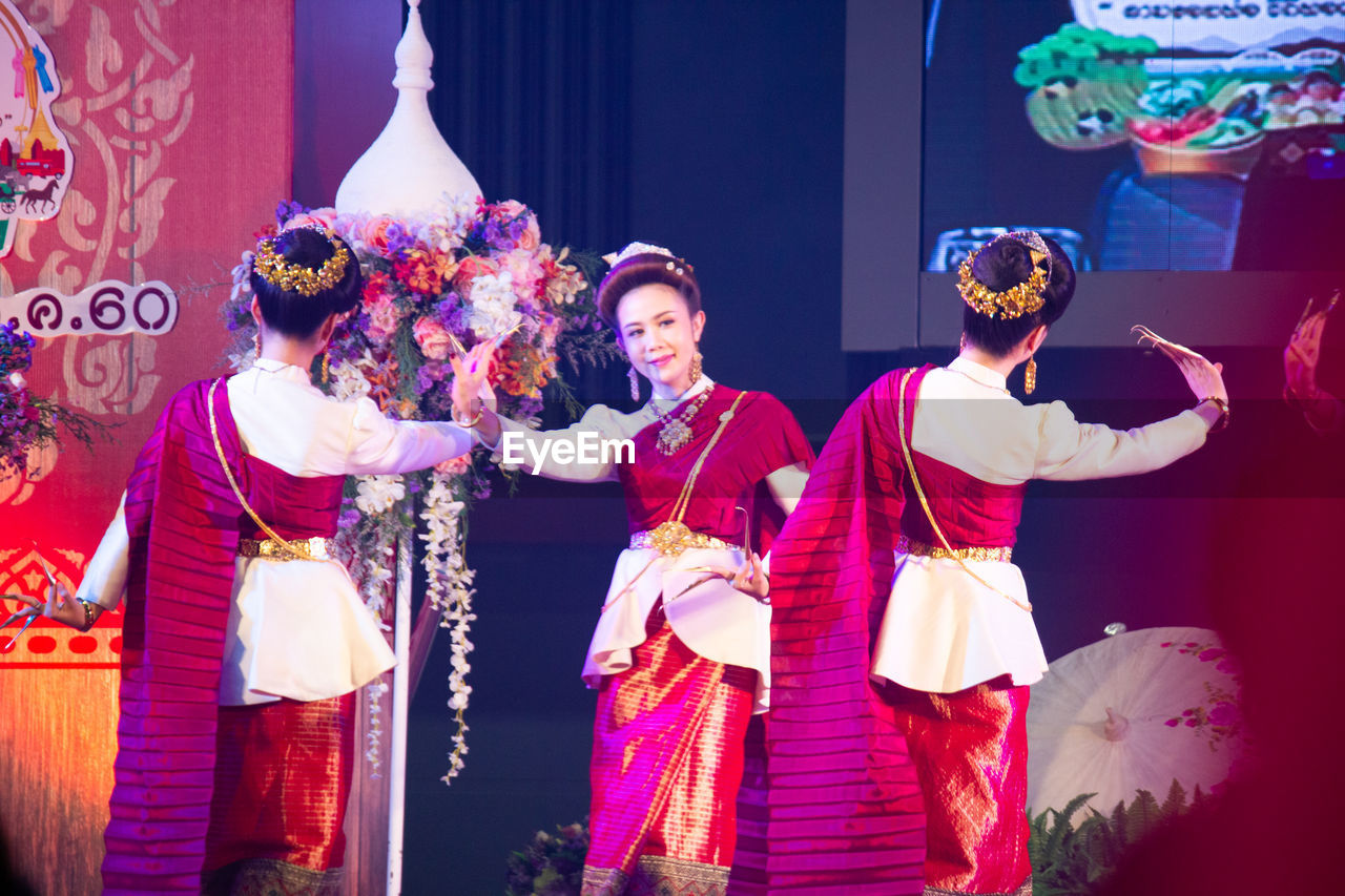 GROUP OF PEOPLE STANDING IN TRADITIONAL CLOTHING