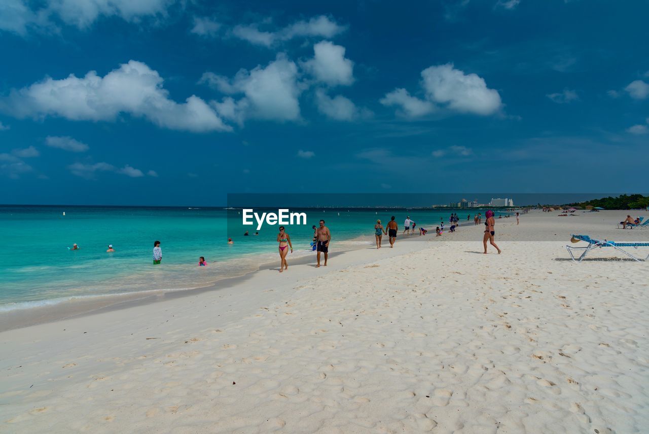 People at beach against sky