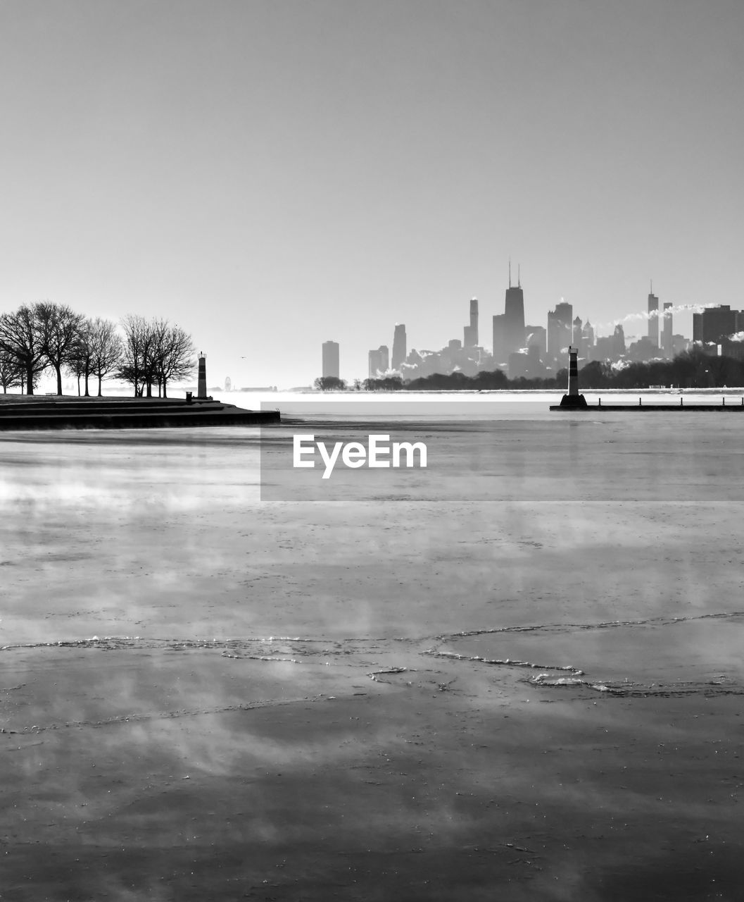 Frozen harbor in winter with big city skyline at dawn