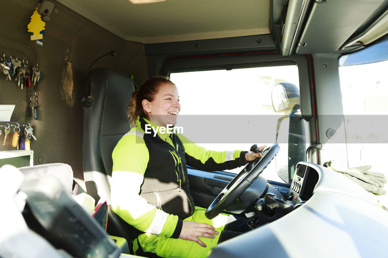 Woman driving garbage truck