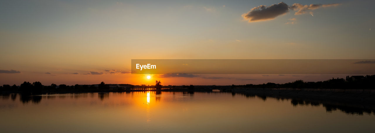 SCENIC VIEW OF LAKE AGAINST ORANGE SKY DURING SUNSET