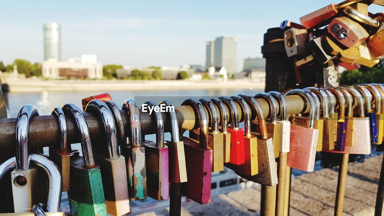 Close-up of love locks hanging on railing in city