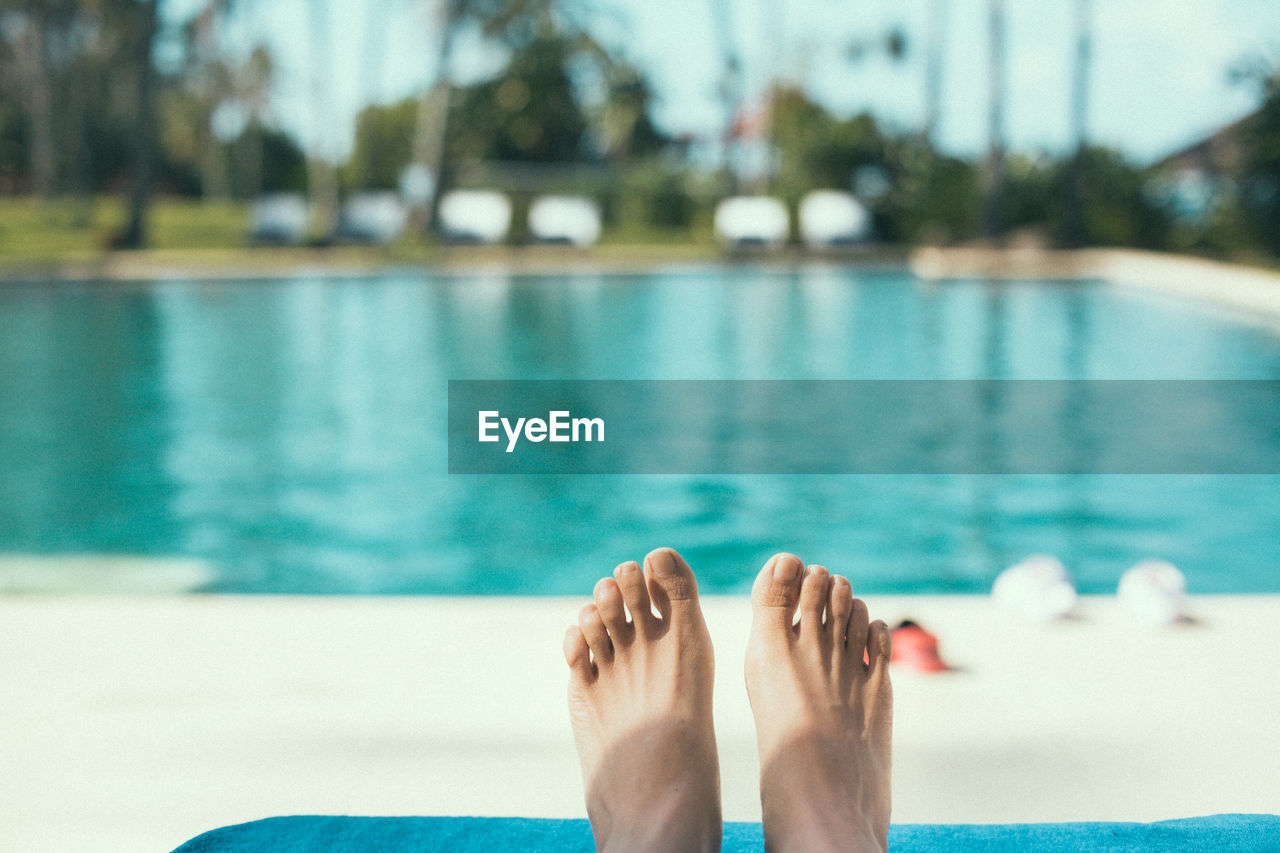 Feet of a woman relaxing at swimming pool