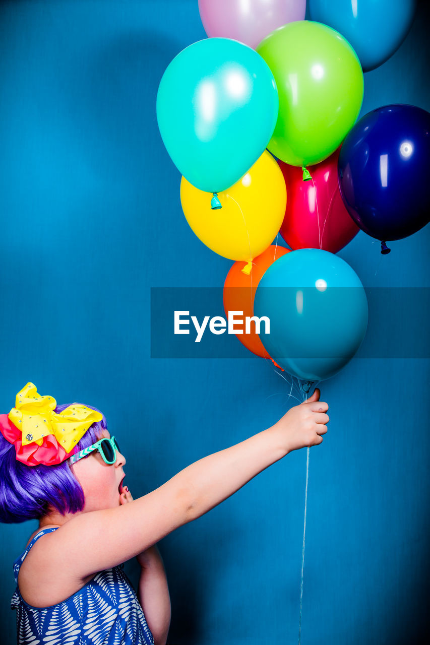 LOW SECTION OF WOMAN HOLDING COLORFUL BALLOONS