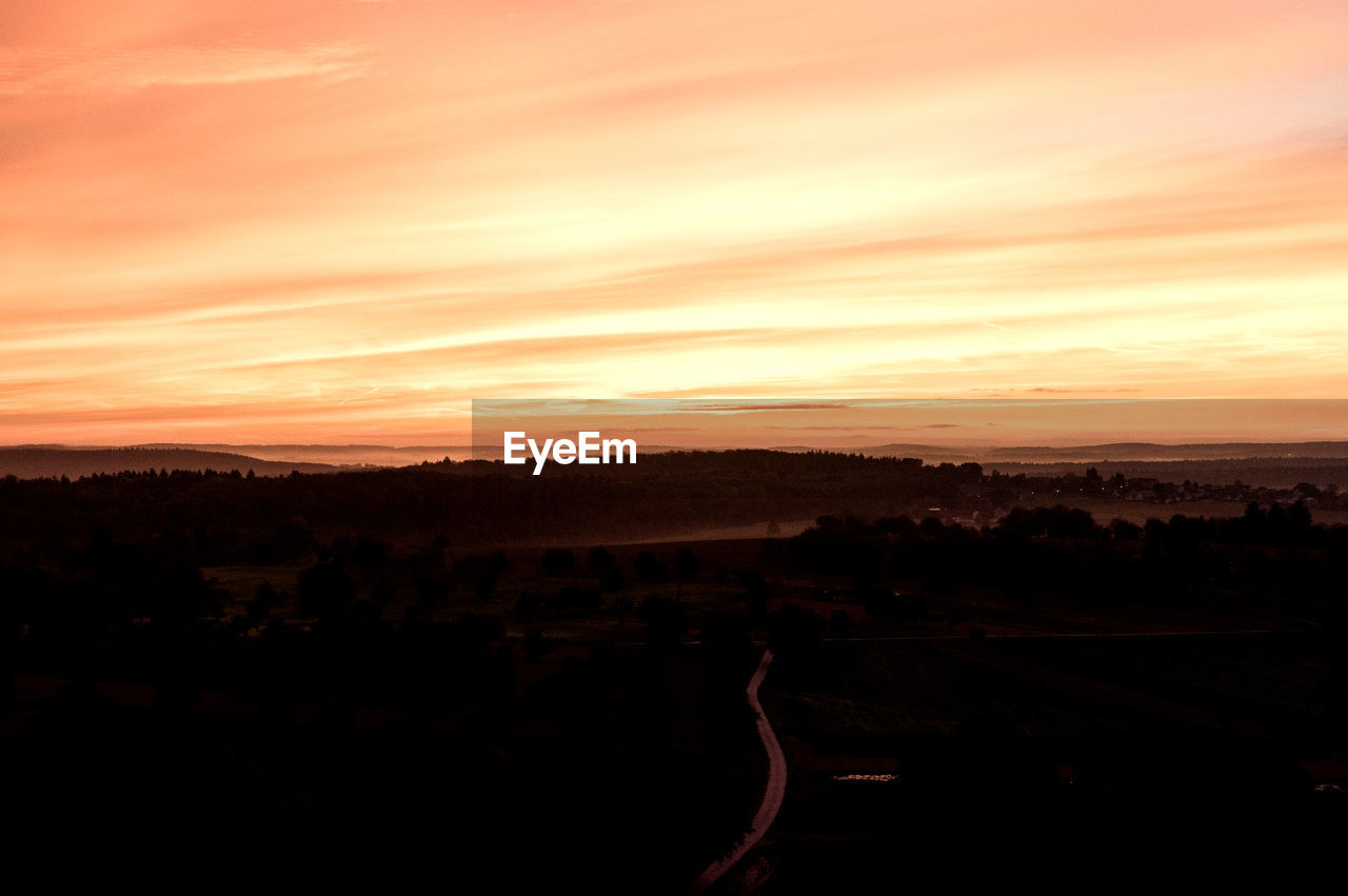 SCENIC VIEW OF SILHOUETTE LANDSCAPE AGAINST DRAMATIC SKY