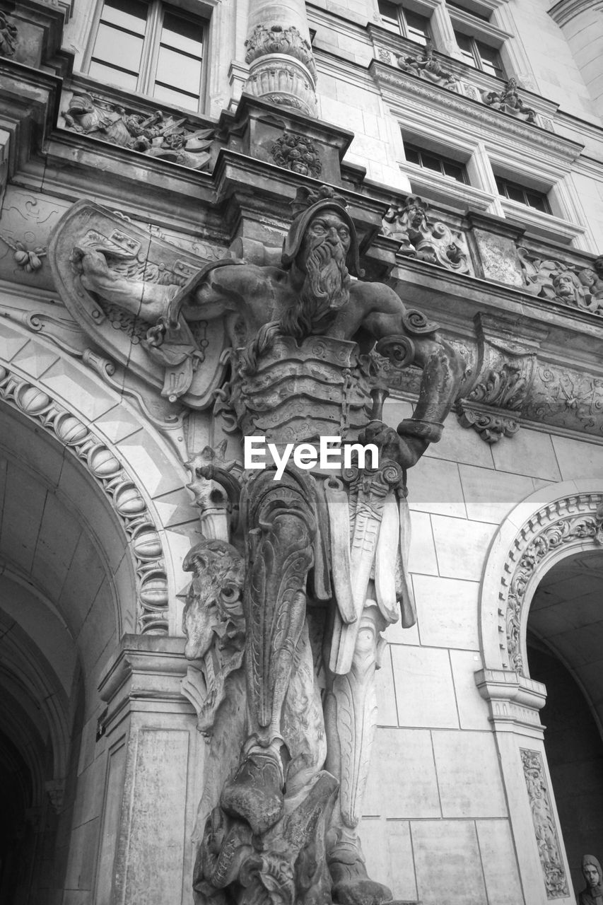 Low angle view of human sculpture on historic building