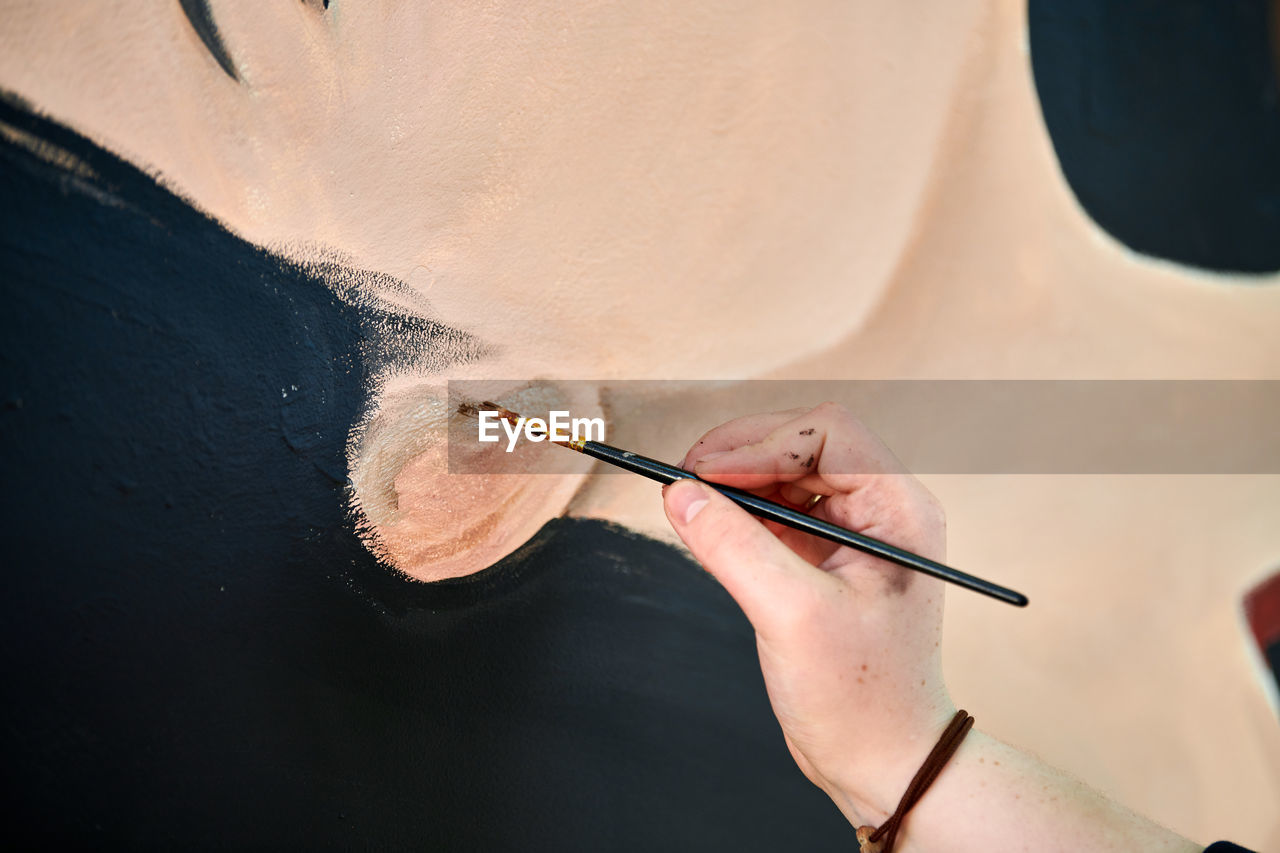 high angle view of woman painting on sand