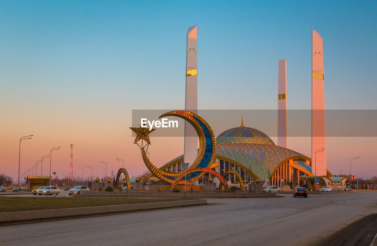 Mosque in the city of argun.  chechen republic. ferris wheel in city against clear sky during sunset
