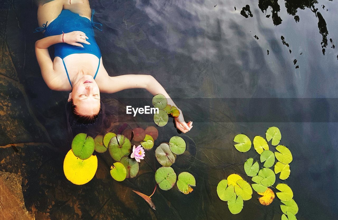 High angle view of mid adult woman relaxing in lake