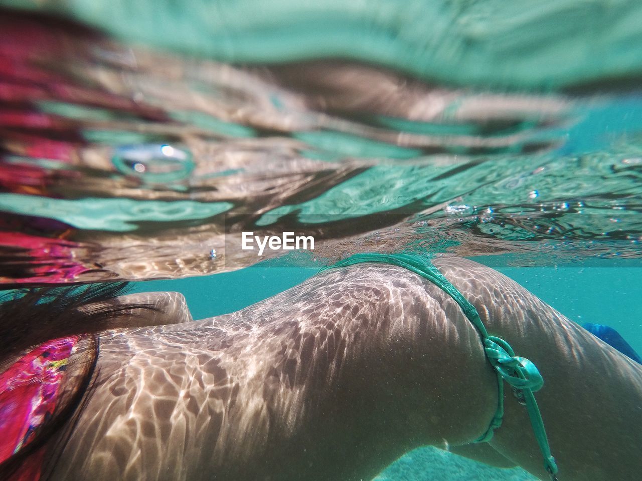 Midsection of woman swimming in pool