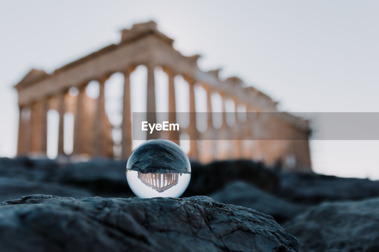 Crystal ball with reflection of old ruin on rock