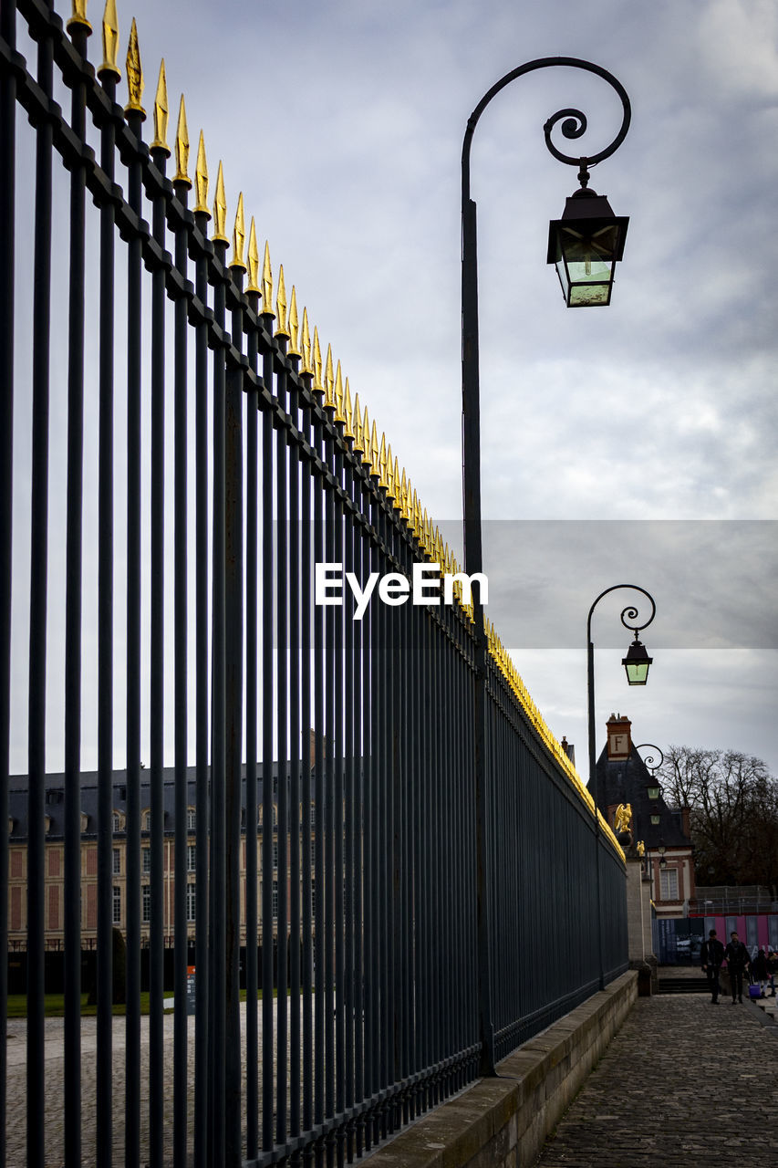 ILLUMINATED STREET LIGHT AGAINST SKY