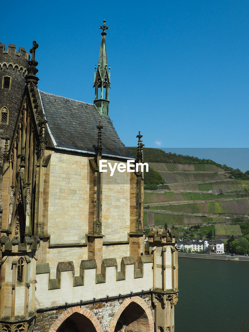 Rheinstein castle by river against clear sky