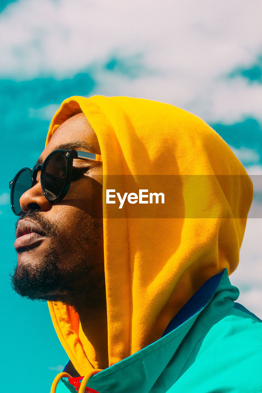 Close-up of man looking away against sky