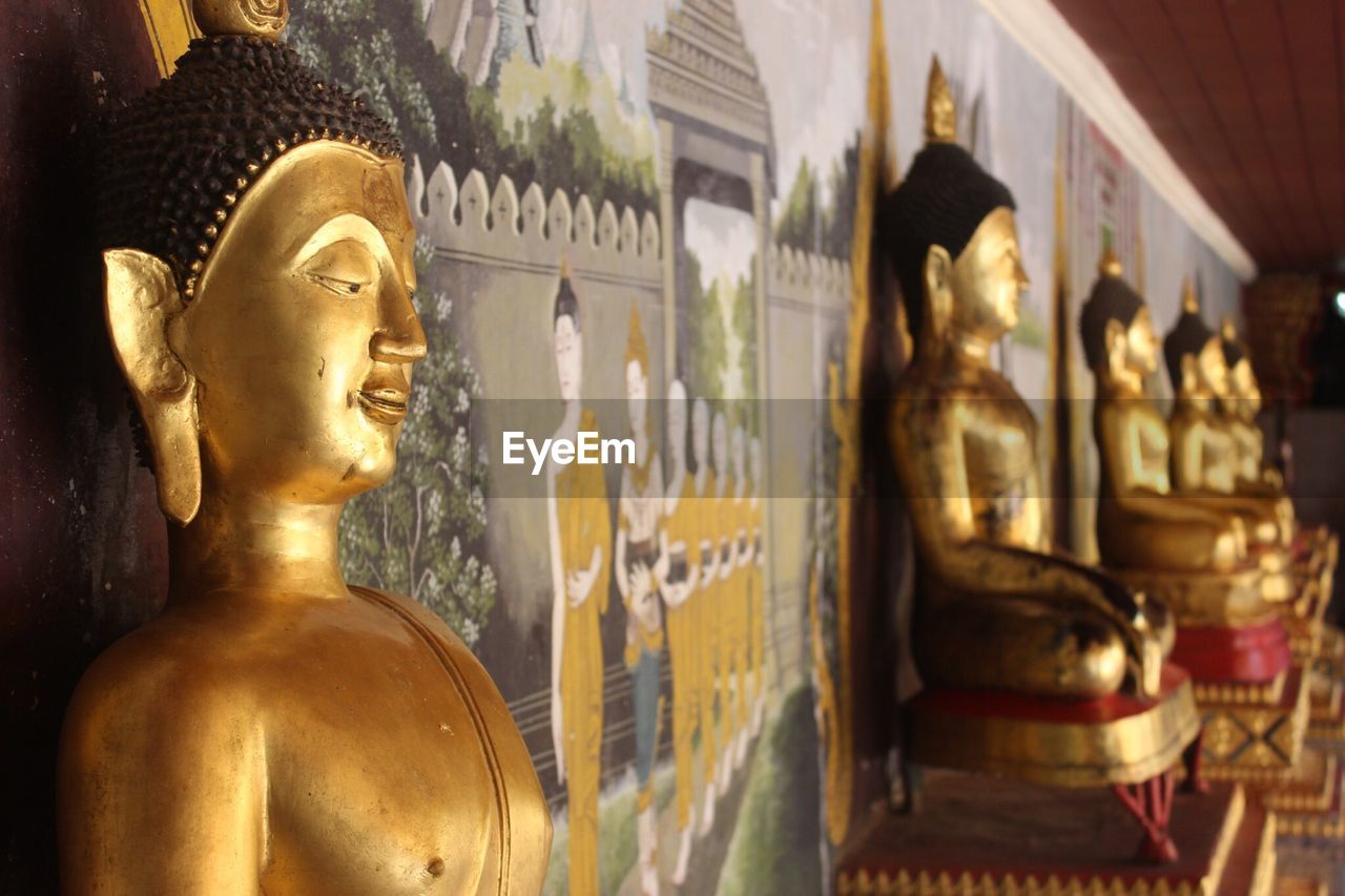 Golden statue of buddha in row at temple