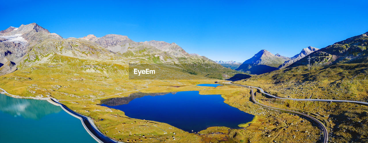 PANORAMIC VIEW OF LAKE AND MOUNTAINS AGAINST CLEAR BLUE SKY