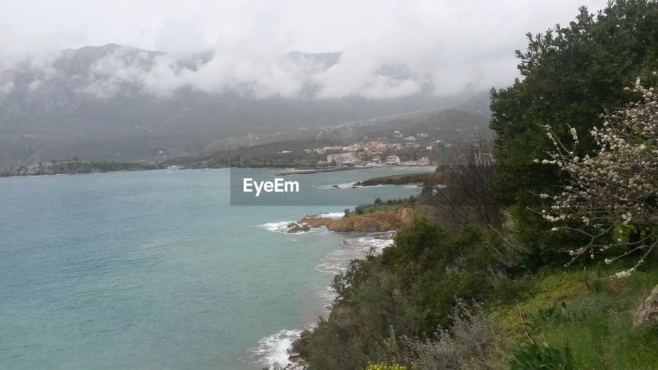 SCENIC VIEW OF SEA WITH MOUNTAIN IN BACKGROUND