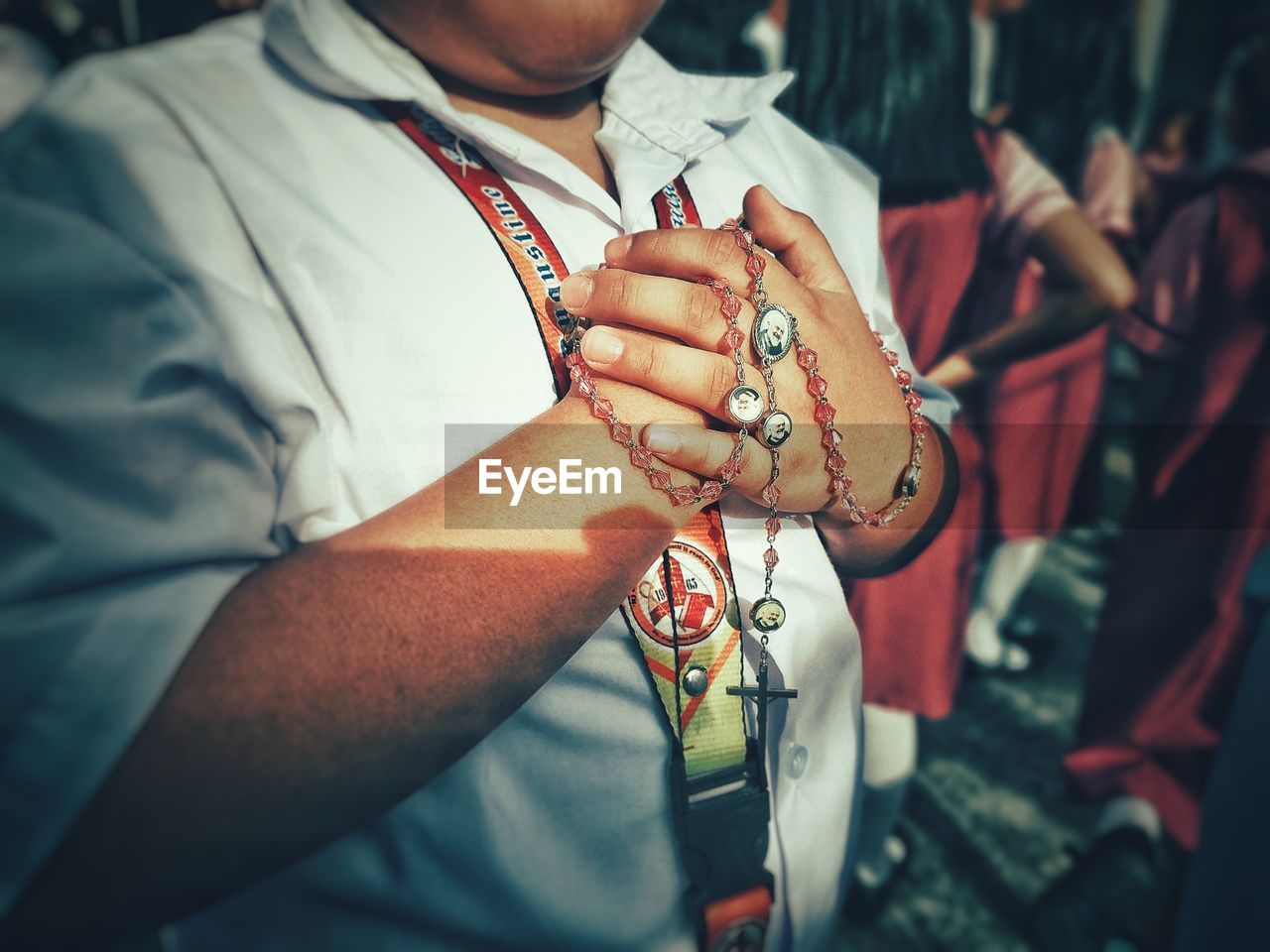 Midsection of man with rosary beads standing outdoors