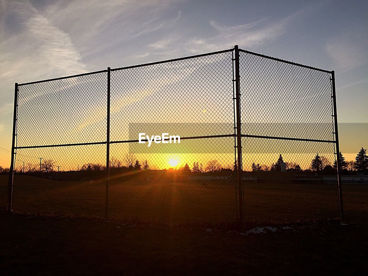 Chainlink fence at sunset