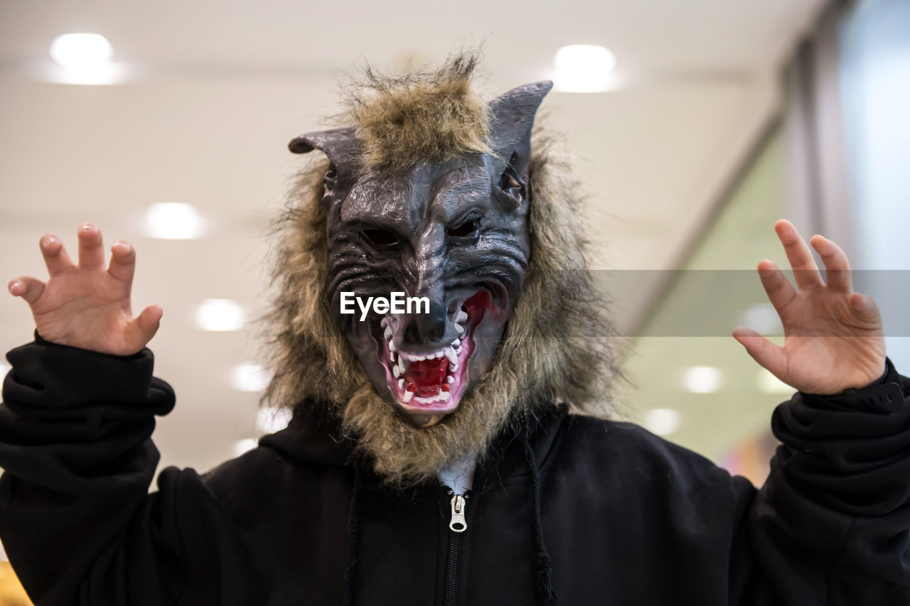 PORTRAIT OF PERSON WEARING MASK HOLDING PAPER