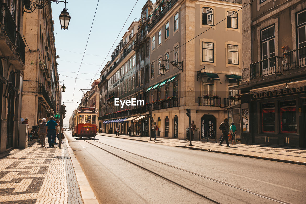 Tramway on street amidst buildings in city